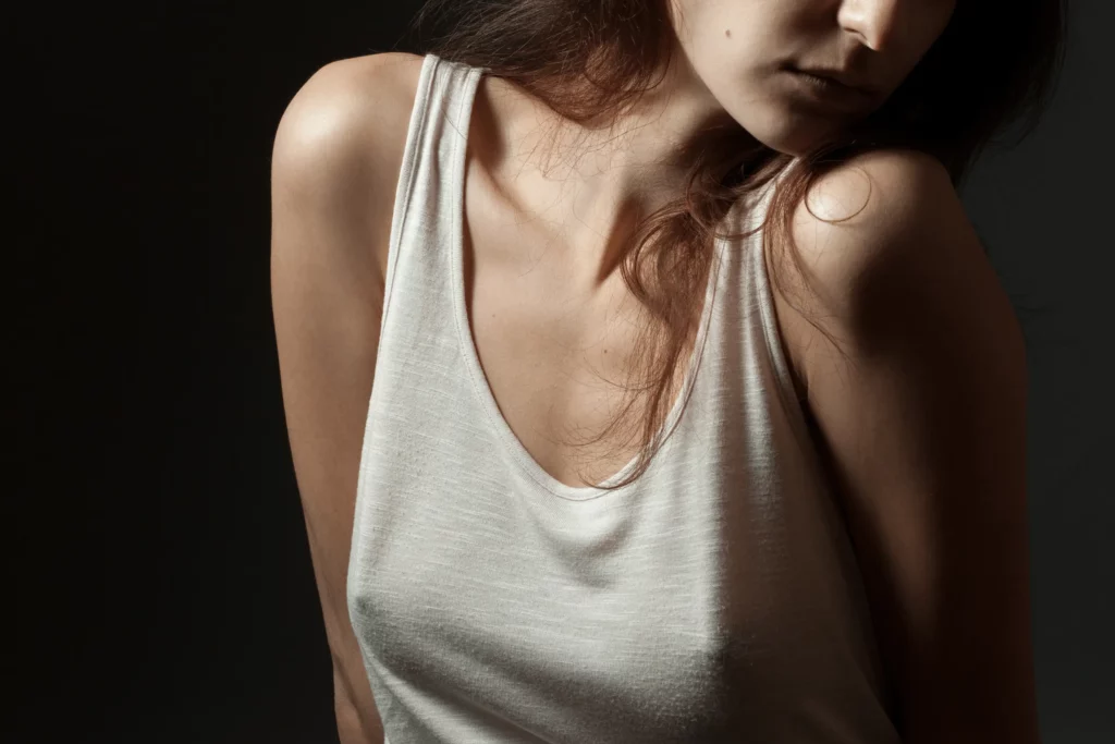 Jeune femme semblant complexée par sa poitrine, et plus précisément par un problème de seins tubéreux.